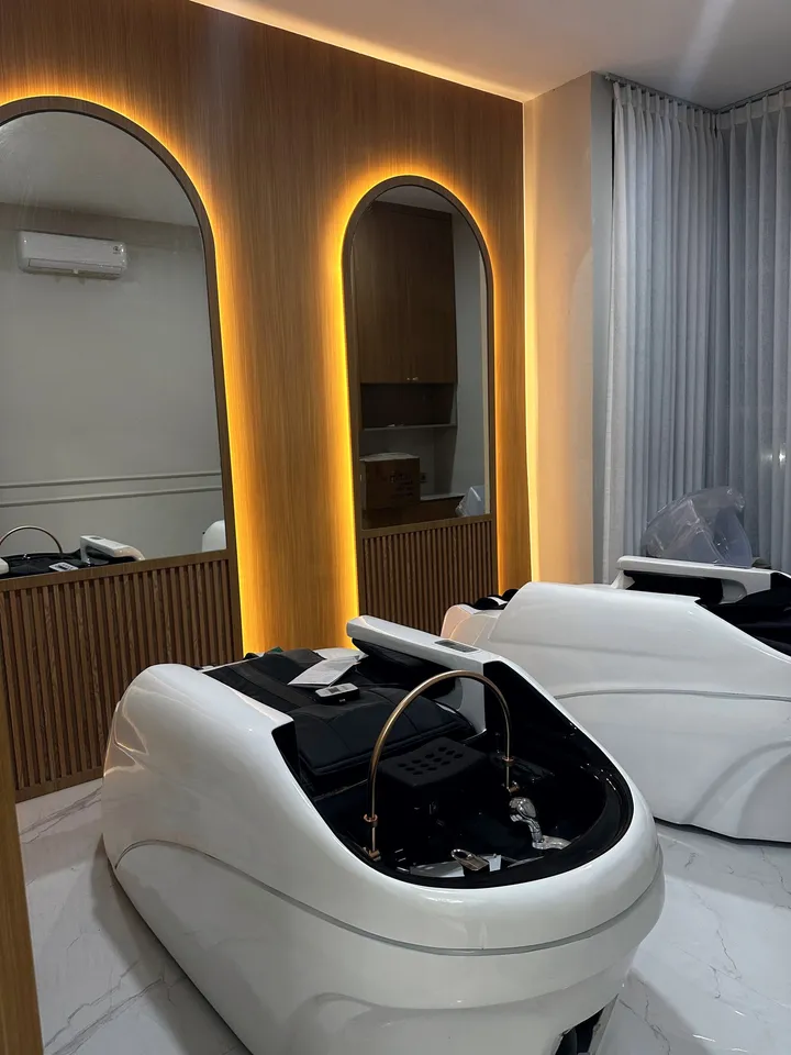 Kursi Japanese head spa putih di depan cermin arch berlampu hangat
